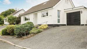 A single-story house with a sloped roof, a garage, and a driveway leading to the entrance.