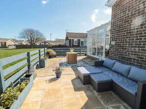 Relax in the patio area with seating and lush greenery.