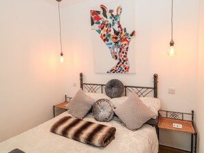 Experience a stylish retreat with a geometric-patterned headboard, abstract artwork, and modern design.