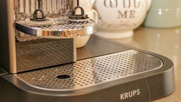 A Krups coffee machine with a perforated drip tray and a control panel.