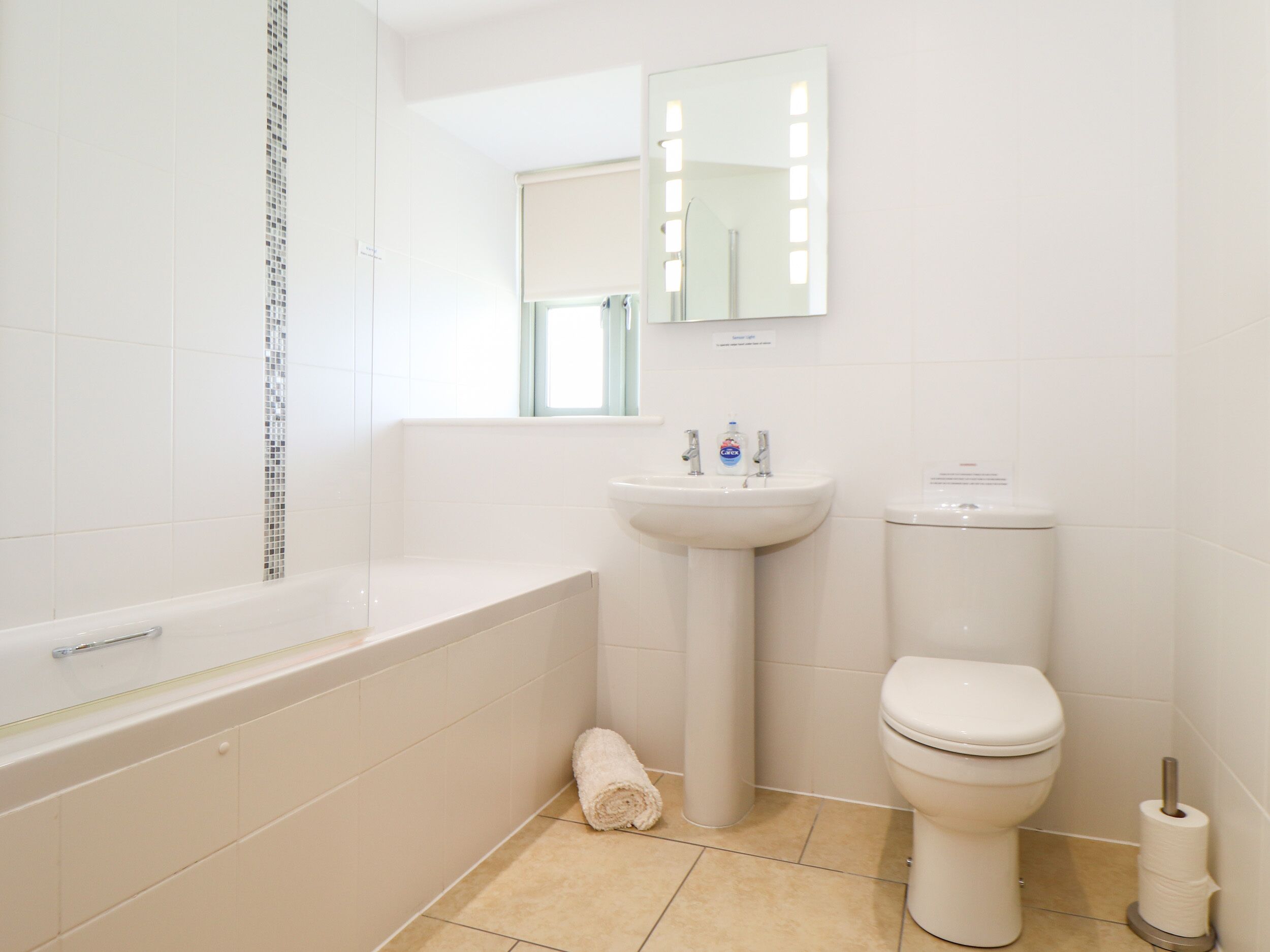 Une salle de bain avec une baignoire, un lavabo, des toilettes et un miroir.