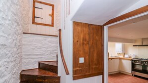 Eine Treppe mit Holzboden und einer Holztür, die in einen Küchenbereich führt.