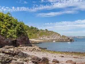 Experience serene coastal tranquility with breathtaking views of the rocky shoreline and calm waters, perfect for boating or fishing.