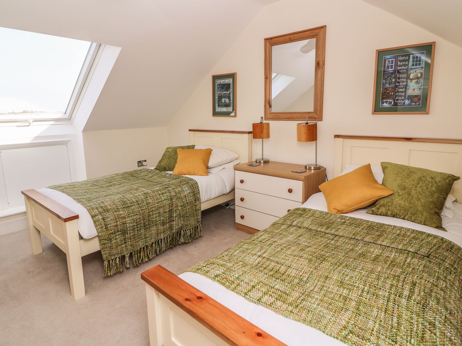 A bedroom with two beds, a nightstand, a dresser, a mirror, and artwork on the walls.