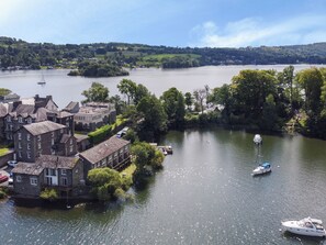Un pueblo a orillas del río con edificios históricos, barcos en el agua y vistas de las colinas circundantes.