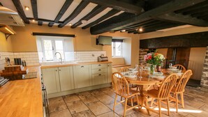 A kitchen with a central island, wooden chairs, and a dining table set for six.
