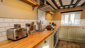 A modern kitchen with a wooden countertop, built-in cabinets, and a stainless steel toaster.