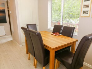 A dining area with a wooden table and four black chairs. - Willow Lodge (Windermere)