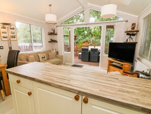 Un amplio espacio de estar con una gran mesa de comedor de madera, un sofá y un televisor.