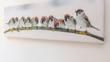 Un tableau représentant une rangée d’oiseaux perchés sur une branche.