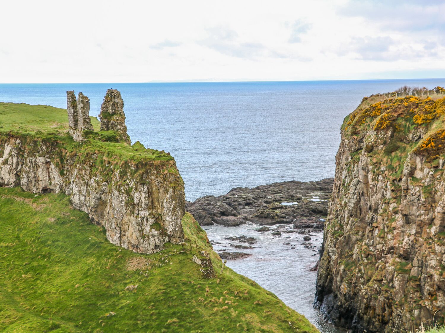 A coastal landscape with rocky cliffs and a view of the sea.