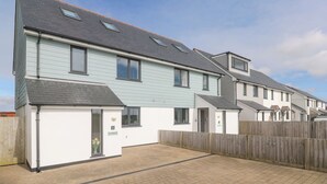 A row of modern two-story houses with a paved driveway and a wooden fence. - Sea Dreams (Marazion)