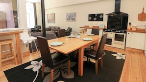 A compact living space with a dining area, kitchenette, and a sofa in the background. - Wye Apartment, Litton Mill (Buxton)