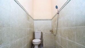 A small, tiled bathroom with a toilet and a shower. - SPOT ON 2011 Hotel Mekar Sari (Surakarta)