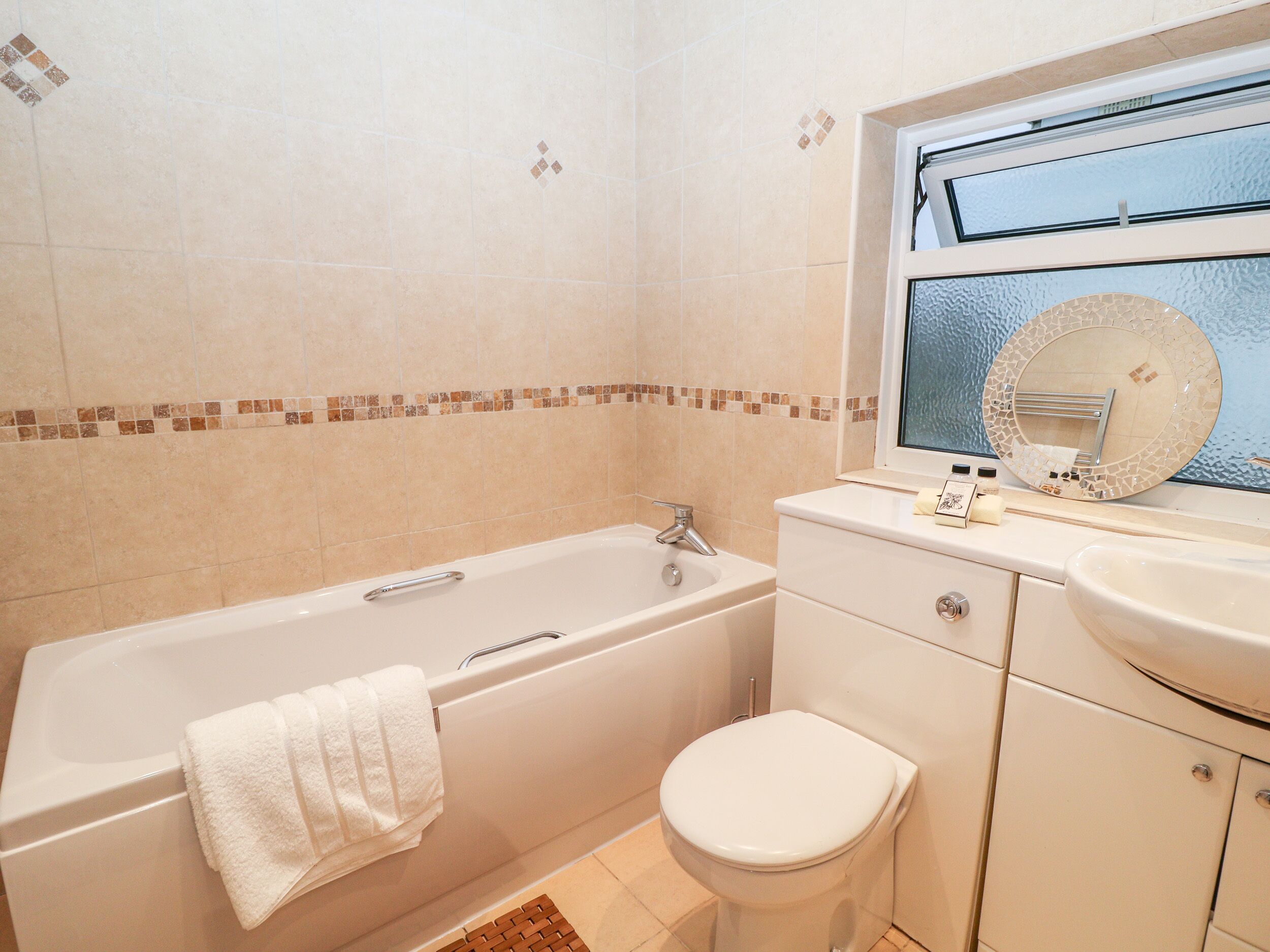 A bathroom with a bathtub, toilet, and sink.
