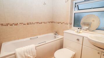 A bathroom with a bathtub, toilet, and sink.