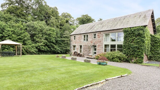 A stone building with a large window, a gravel driveway, and a grassy lawn. - Cardean Mill (Blairgowrie)