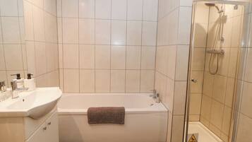 Un baño moderno con bañera, ducha y lavabo.