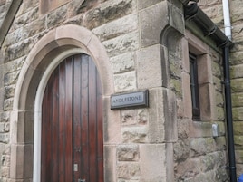 Un edificio de piedra con puerta de madera y un letrero que dice 'ANDLESTONE'.