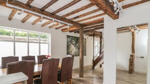 Un comedor espacioso con techo de madera y ventanas amplias.