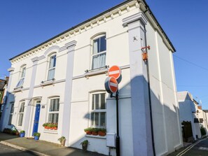 A white building with a blue door, potted plants, and a no entry sign. - Lancaster House (Sandown)