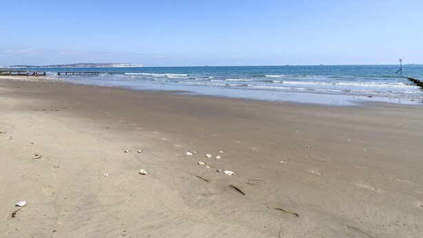 A beach with a clear sky, calm sea, and a pier in the distance. - Lancaster House (Sandown)