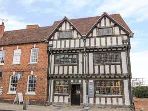 A traditional half-timbered building with a sign for a books sale. - Treacle Cottage (Warwick)