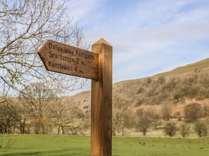 A wooden directional signpost with distance markers for Dales Way Footpath, Starbotton, and Kettlewell.