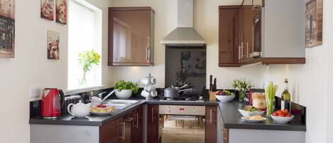 A modern kitchen with wooden cabinets, a central island, and various appliances.