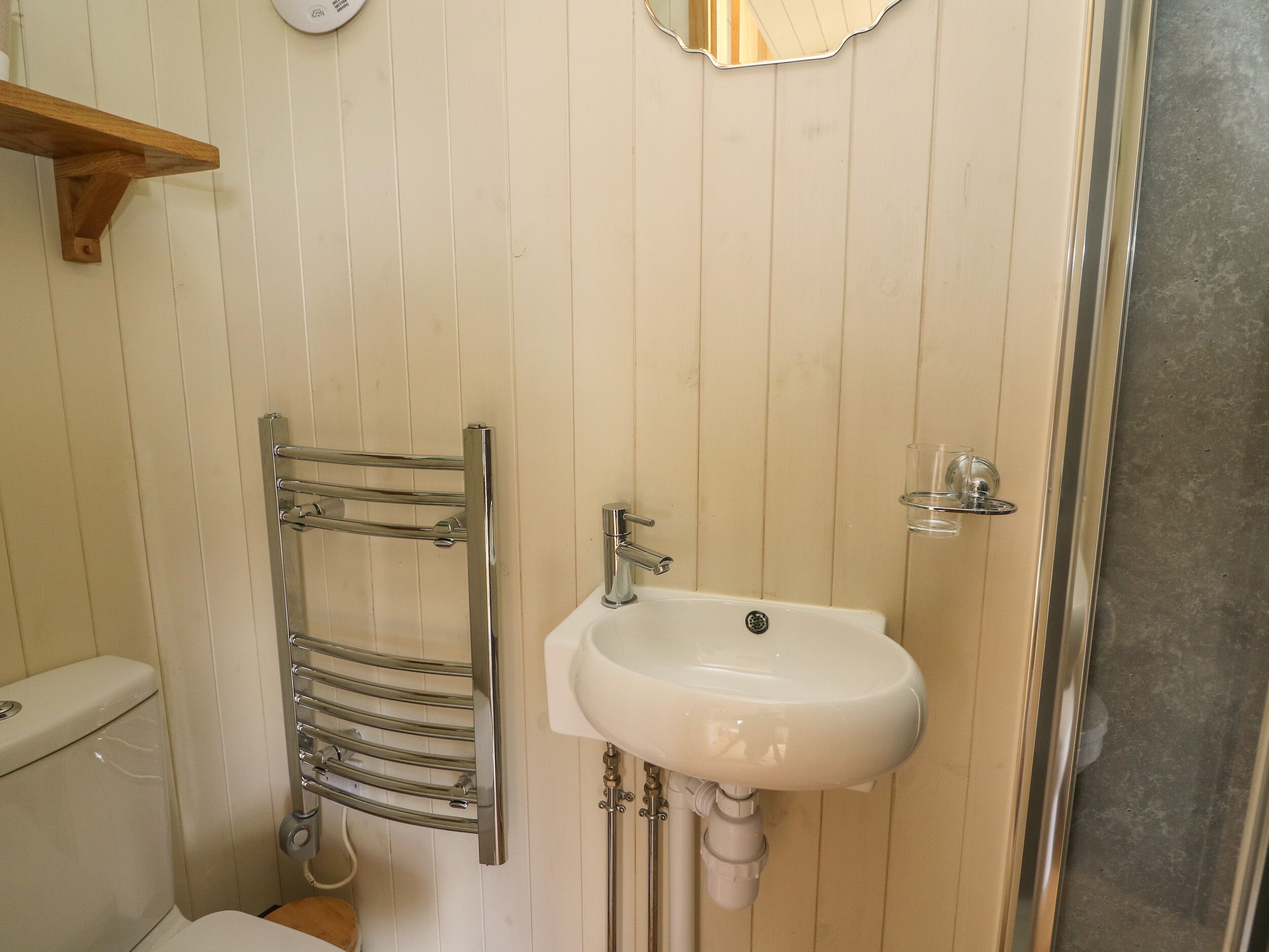 Een badkamer met een wit wastafel, een chroom handdoekrek en een toilet.