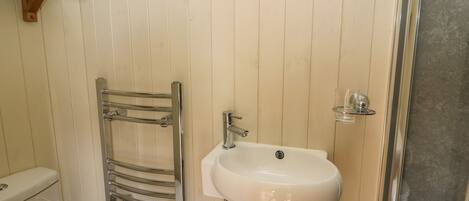 Een badkamer met een wit wastafel, een chroom handdoekrek en een toilet.