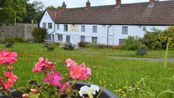 Step into the charming atmosphere of The Poppy Inn, surrounded by a beautifully maintained garden.