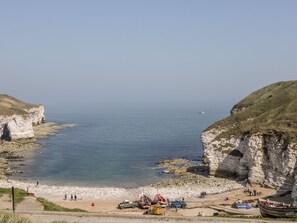A coastal beach with cliffs, a sandy shore, and a clear sky. - Chalkstone Cottage (Bridlington)