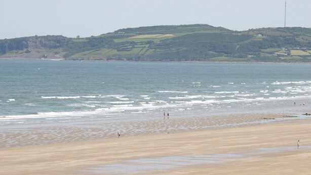 A beach with a sandy shore and waves.