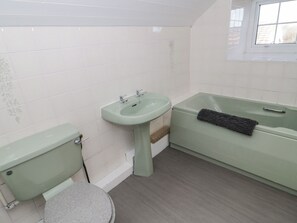 A bathroom with a toilet, sink, and bathtub. - Rhous (Tyn-y-Gongl)
