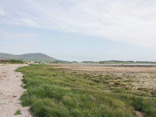 A rural landscape with a gravel path, grassy areas, and distant hills. - Mardan (Dumfries)