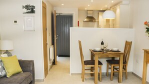 A modern kitchen with a dining table and chairs, a sofa with a cushion, and a lamp. - Gilson (Ambleside)