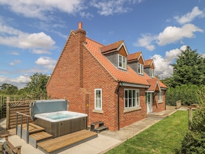 A two-story brick house with a hot tub and wooden deck. - Wayside Cottage (York)
