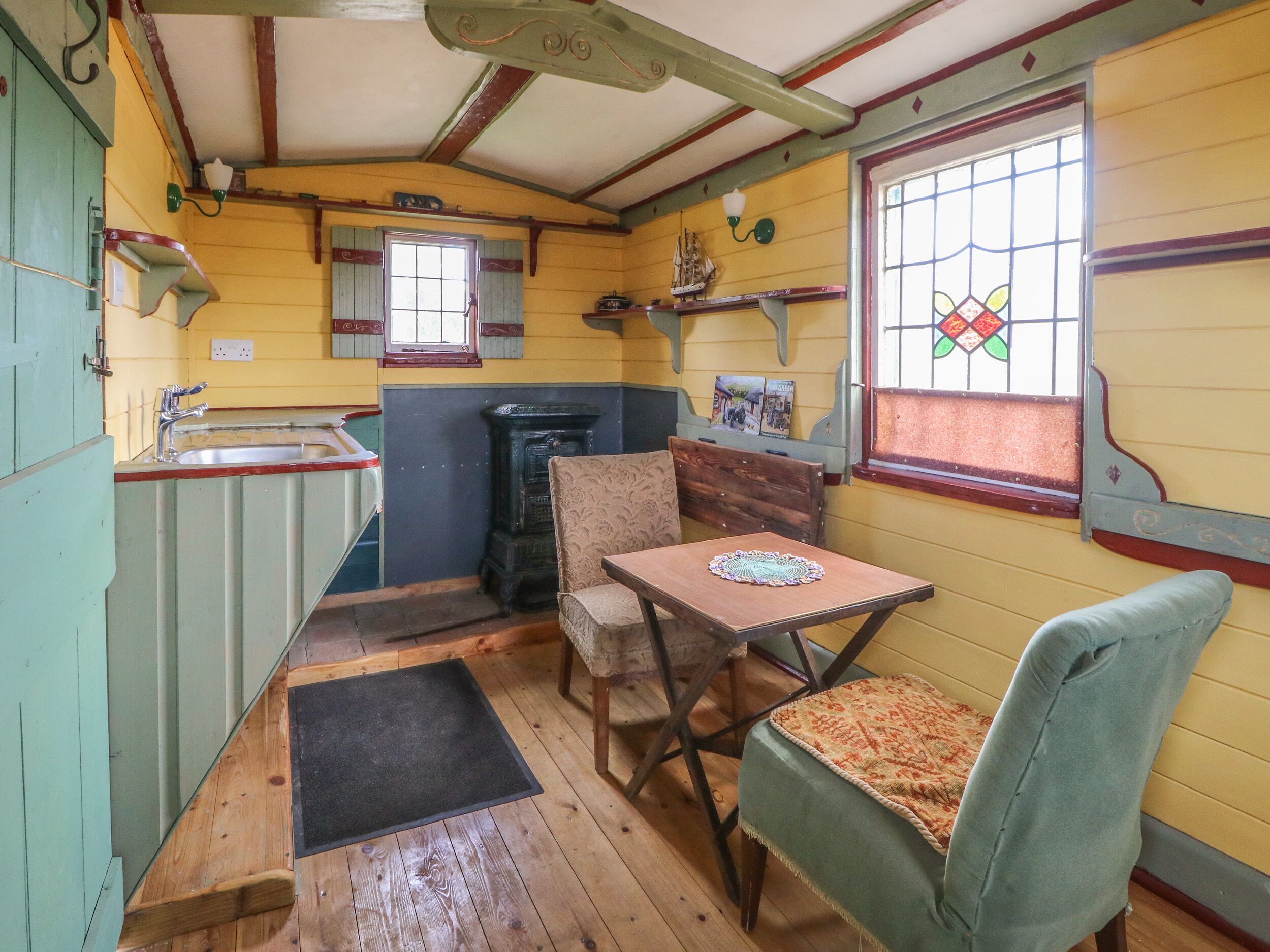 A compact kitchen with a sink, a stove, and a small dining area with a table and two chairs.