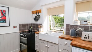 Une cuisine moderne équipée d’une cuisinière, d’un four, d’un évier et d’une machine à café.