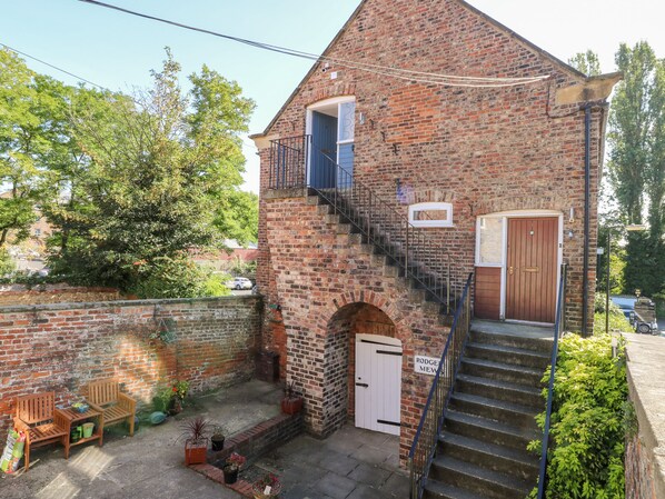 Un edificio de ladrillo con una escalera que lleva a una puerta con la leyenda "Rodger & Mews".