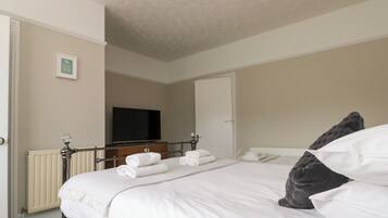 Habitación de hotel con cama, televisor y radiador.