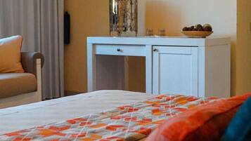 Una camera d'albergo con un letto, un comodino, una lampada e una finestra con tende.