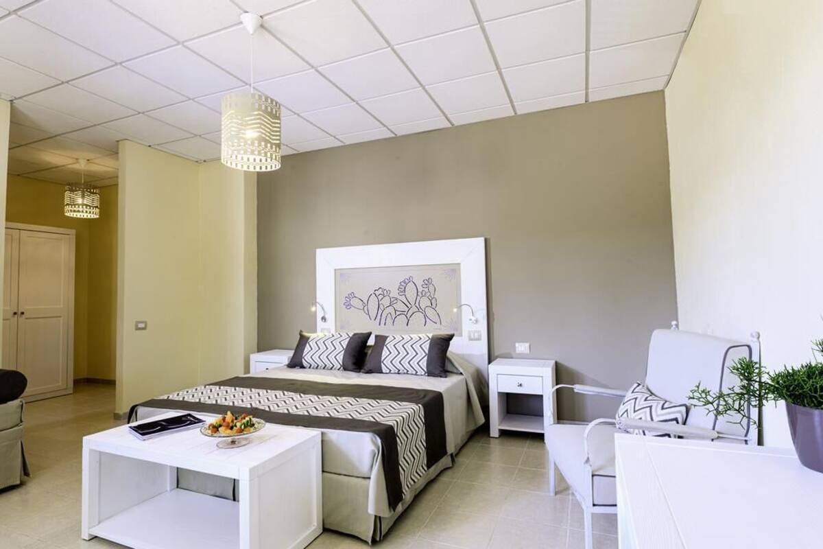 Un dormitorio moderno con una cama, mesitas de noche, un escritorio y una silla.