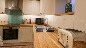 A compact kitchen with a built-in oven, a toaster, and a sink.