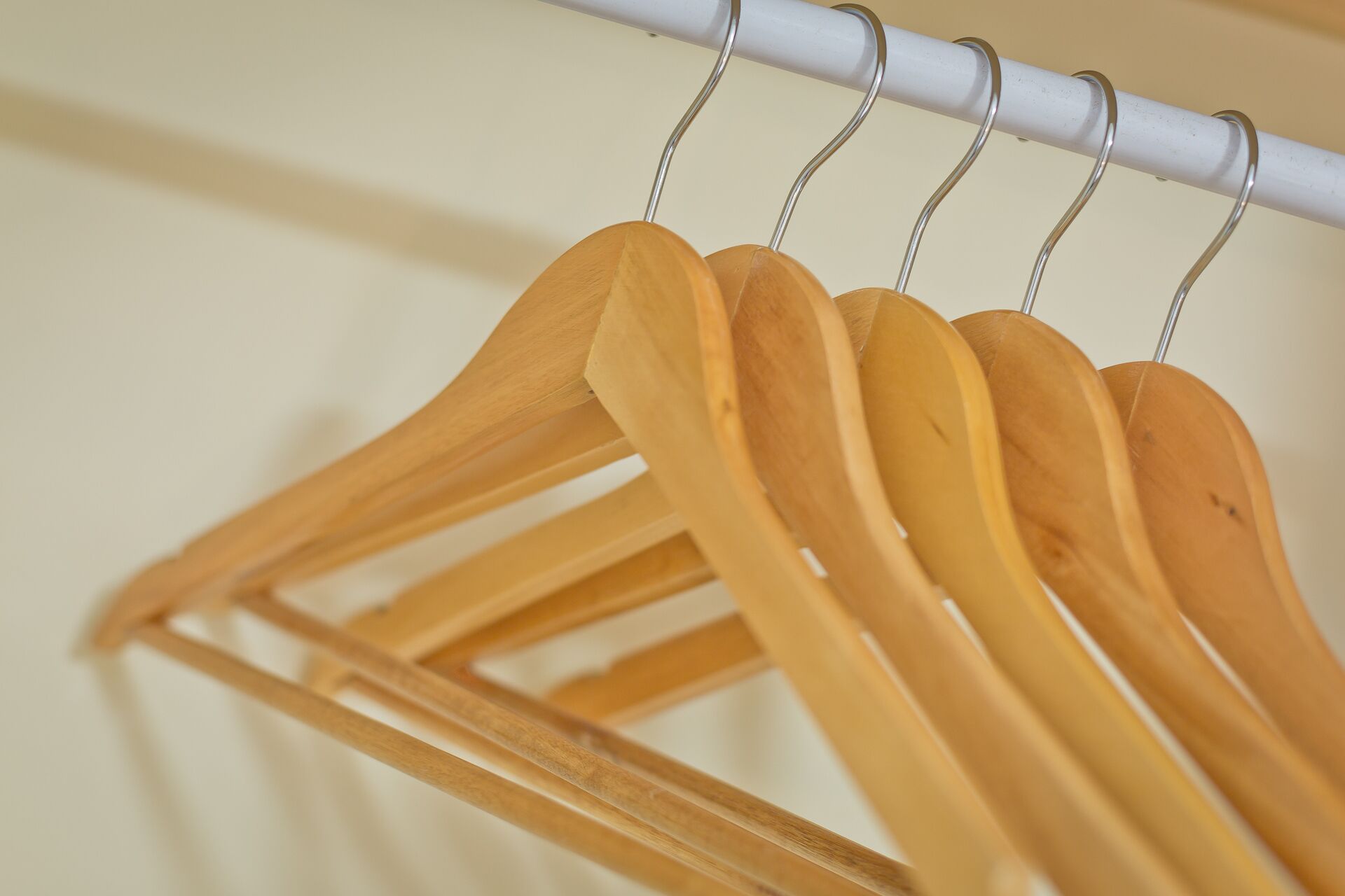 A wooden hanger rack with multiple hangers.