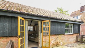 A two-story house with a brick exterior, a tiled roof, and a front door with glass panels. - The Bull Pen (Eye)