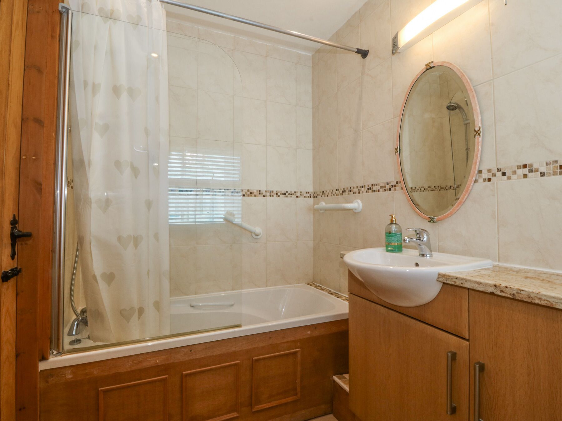 Ein Badezimmer mit Dusche, Waschbecken und Spiegel.