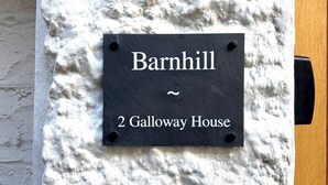 A black sign with white lettering on a textured wall, indicating "Barnhill 2 Galloway House". - Flat 2 Galloway House (Kendal)