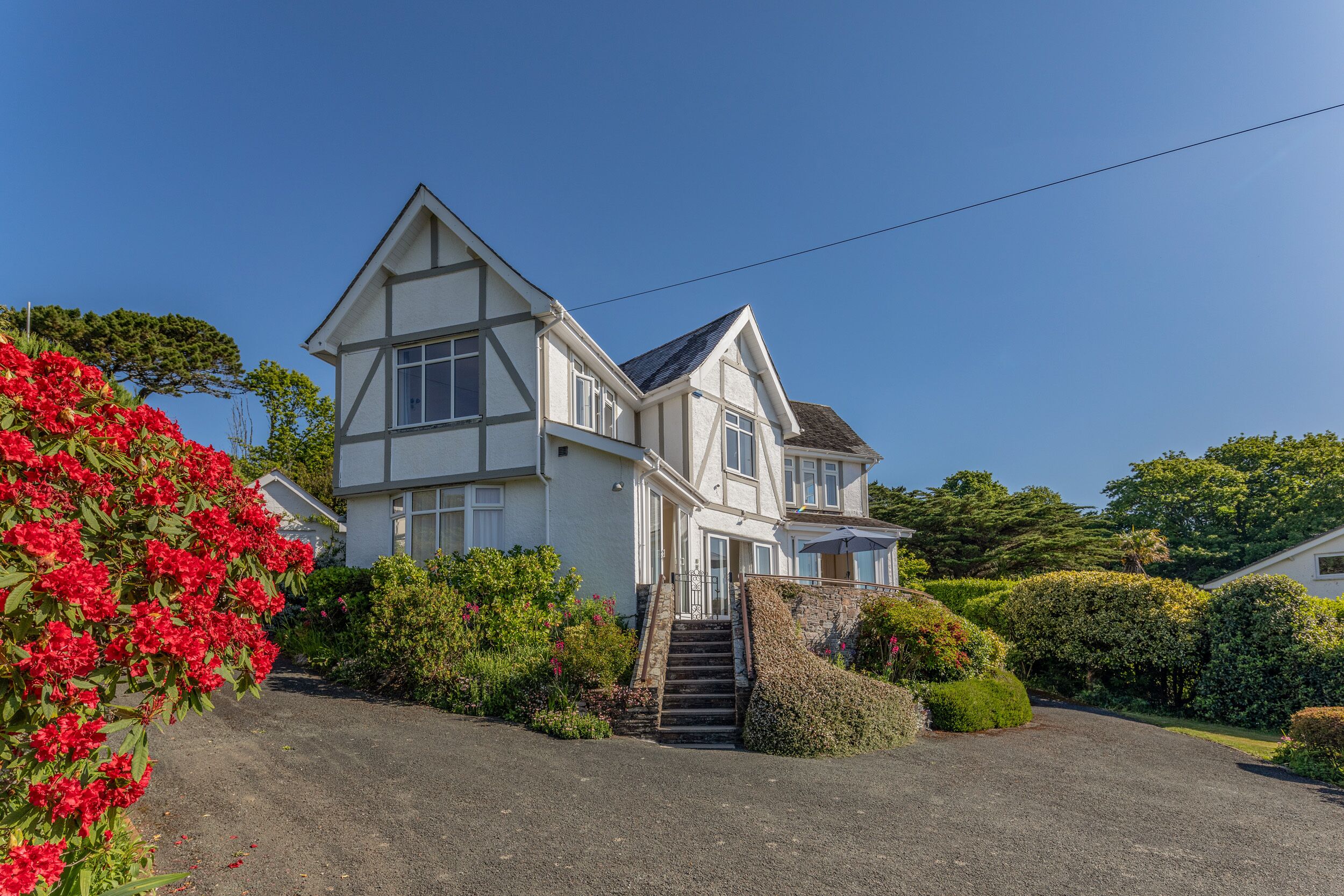 A two-story house with a steep driveway and a small staircase leading to the entrance.
